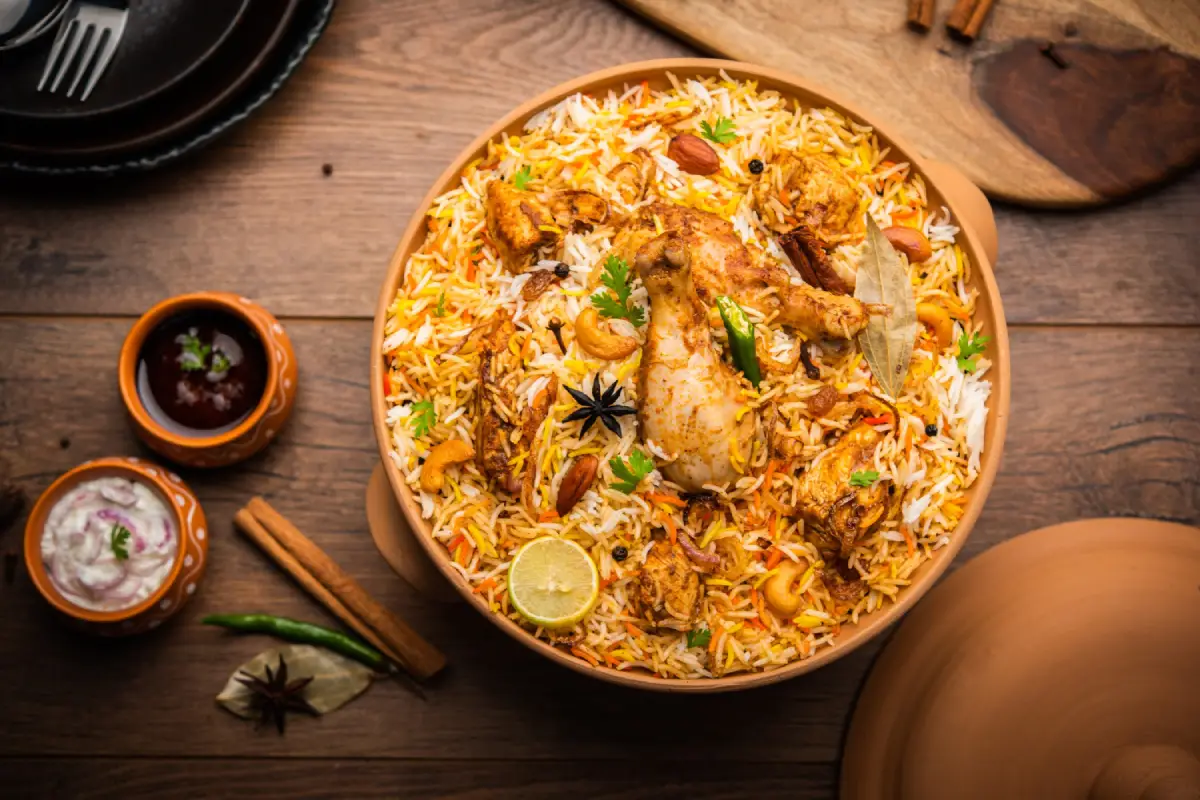 Aromatic chicken biryani garnished with herbs and spices in a traditional clay bowl.