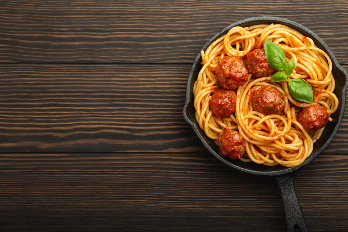 Spaghetti with savory meatballs and fresh basil.